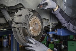 Picture of a mechanic servicing a cars brake rotor