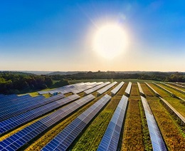 Aerial photo of a solar farm with sun in the background